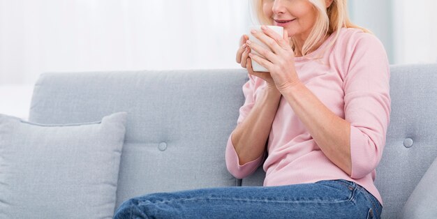 Ładna starsza kobieta cieszy się kawę w domu