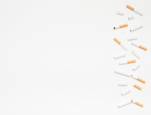 Bezpłatne zdjęcie Łamani papierosy układali na dnie nad odosobnionym na białym tle