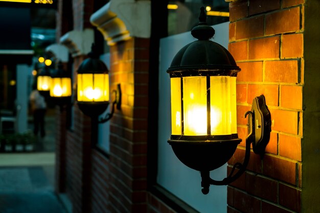 Lampa przeciwko czerwonej cegły ściany w nocy.