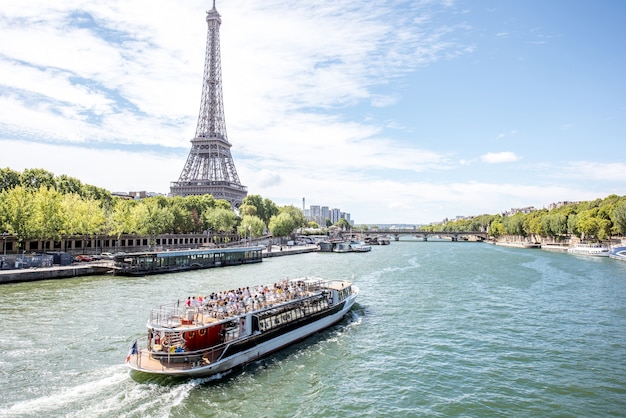 Landscpae widok na wieżę eiffla i sekwaną z łodzią turystyczną w paryżu