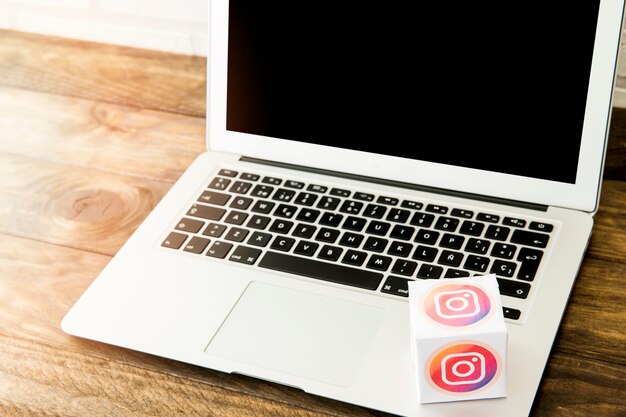 Laptop z instagram ikony pudełkiem na biurowym biurku