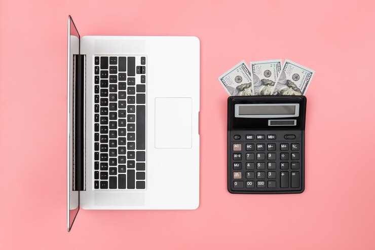 Bezpłatny plik Zdjęcie laptop z kalkulatorem i banknoty na kolorowym tle