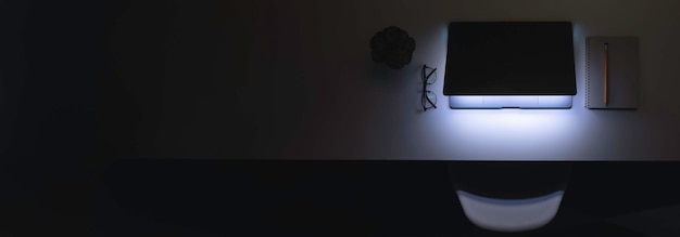 Bezpłatne zdjęcie laptop z świecącym ekranem na stole w ciemnej przestrzeni kopiowania widoku górnego