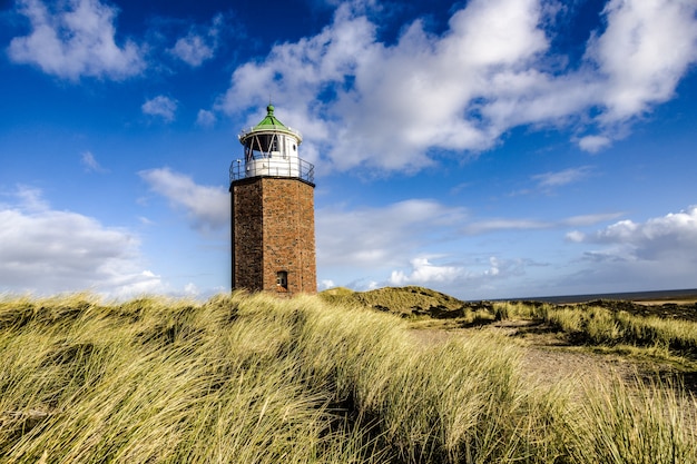 Latarnia morska Quermarkenfeuer w Kampen, Sylt, Niemcy pod zachmurzonym niebem