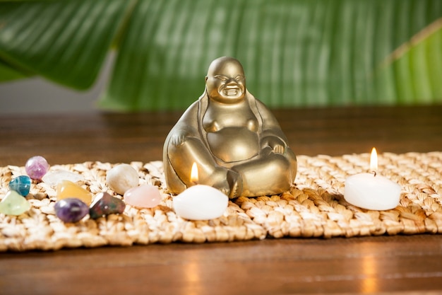 Bezpłatne zdjęcie laughing buddha figurkę, kamyczki kamień i zapalił świece