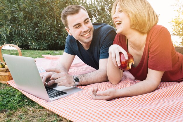 Laughing para za pomocą laptopa na piknik