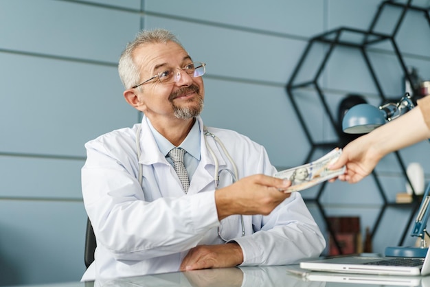 Lekarz bierze łapówkę pieniężną do koncepcji medycyny opłacanej przez lekarza