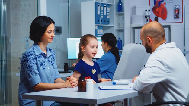 Lekarz daje piątkę z małym pacjentem w gabinecie lekarskim. Lekarz, lekarz, specjalista medycyny udzielający świadczeń zdrowotnych konsultacja diagnostyczna leczenie szpitalne.