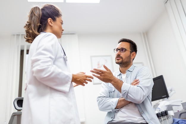 Lekarz pracujący w gabinecie i słuchający pacjenta wyjaśnia swoje objawy koncepcji opieki zdrowotnej i pomocy