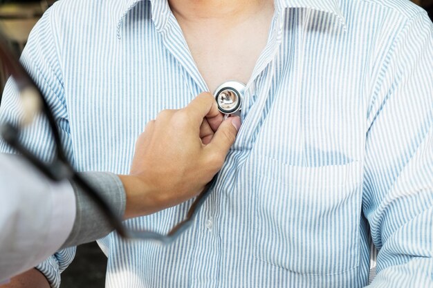 Lekarz słucha wesoły młodych pacjentów klatki piersiowej z stetoskop w jego biurze w szpitalu.