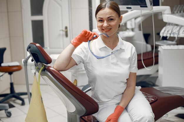 Lekarz trzyma okulary. Kobieta patrząc w kamerę Dentysta czeka na pacjenta