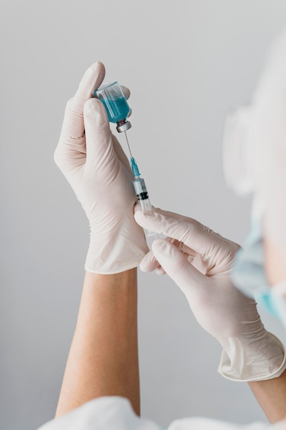 Bezpłatne zdjęcie lekarz trzymając strzykawkę do szczepionki
