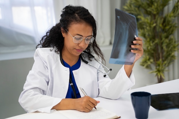 Bezpłatne zdjęcie lekarz trzymający średni strzał radiografii