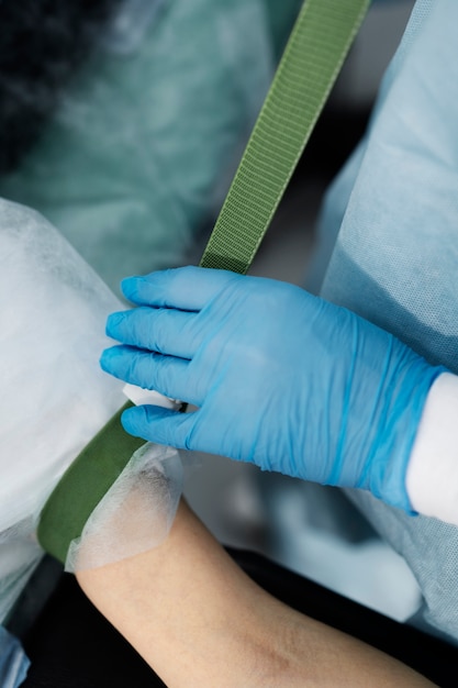 Bezpłatne zdjęcie lekarz umieszczający kroplówkę na ramieniu pacjenta