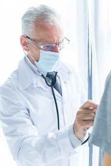 Lekarz w masce badanie pacjenta upraw