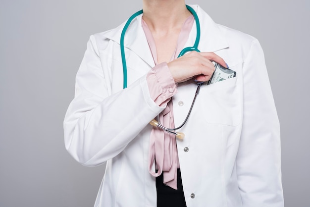 Lekarz wkładający łapówkę do jej kieszeni