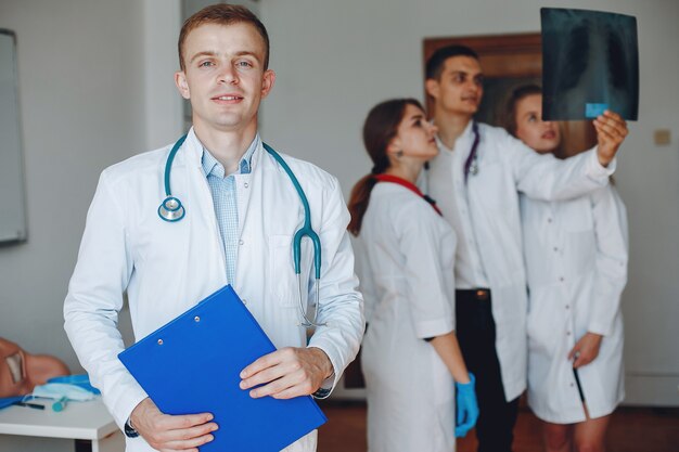 Lekarz z folderem w dłoniach patrzy w kamerę