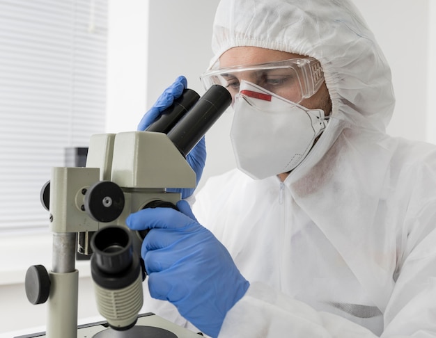 Lekarz za pomocą mikroskopu do sprawdzenia próbki COVID