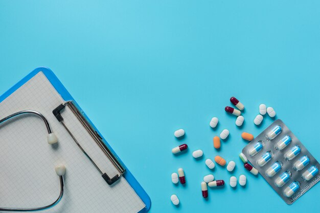 leków, materiałów medycznych umieszczonych obok tablic do pisania i narzędzi lekarza na niebiesko.