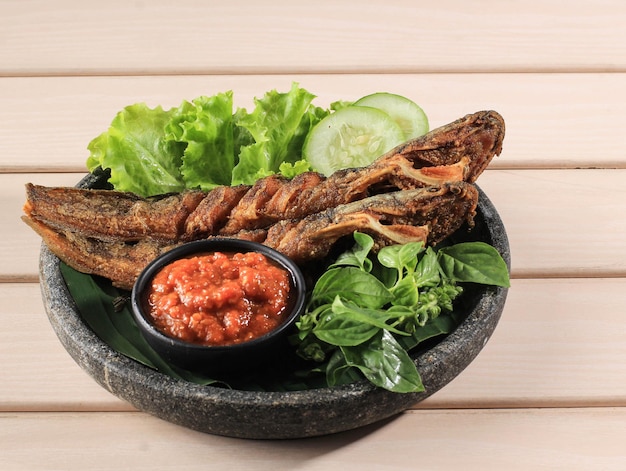 Lele goreng lub smażony sum to tradycyjna indonezyjska potrawa kulinarna. pasta pomidorowa z suma i chilli, popularne jedzenie uliczne o nazwie pecel lele lamongan
