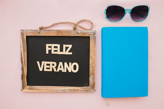 Bezpłatne zdjęcie letnia kompozycja z okularami przeciwsłonecznymi, książką i łupkiem