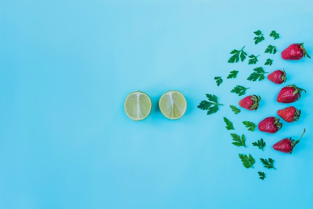 Bezpłatne zdjęcie letnia kompozycja z ozdobnymi truskawkami, limonkami i natką pietruszki