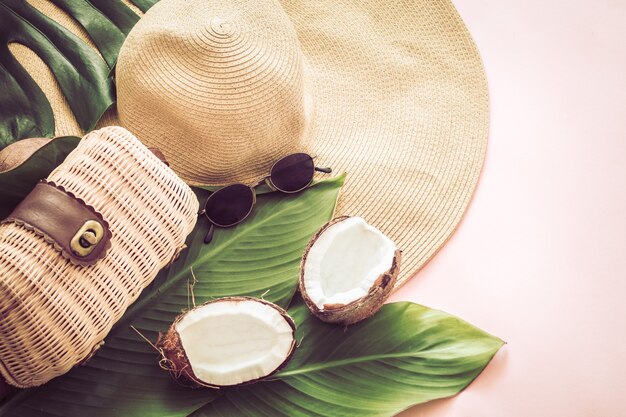 Letnia stylowa martwa natura z kapeluszem plażowym i kokosem na różowym tle, pop-art. Widok z góry, zbliżenie, koncepcja kreatywna