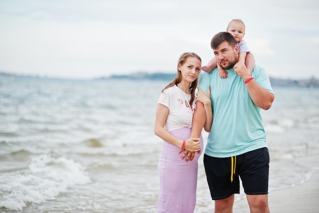 Letnie wakacje Rodzice i ludzie aktywność na świeżym powietrzu z dziećmi Szczęśliwe rodzinne wakacje Ojciec w ciąży matka córeczka na morskim piasku plaży