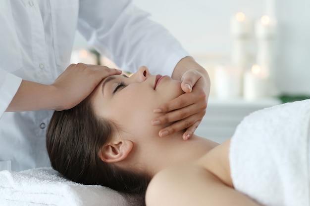 Leżąca kobieta otrzymująca masaż. Terapia czaszkowo-krzyżowa
