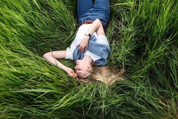 Bezpłatne zdjęcie leżał płasko kobiety pozowanie w trawie