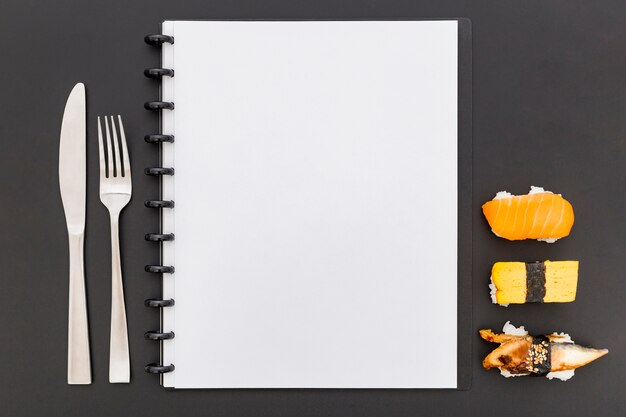 Leżał płasko pusty notatnik menu z sushi i sztućcami