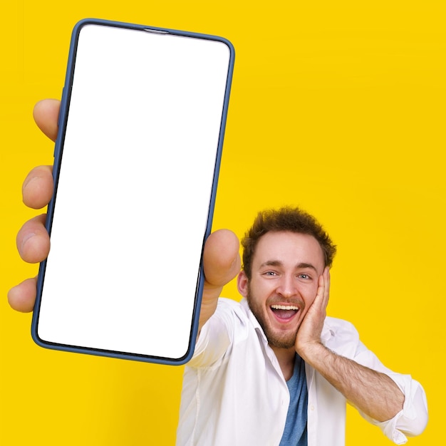 Lokowanie produktu w reklamie aplikacji mobilnej Świetna oferta Młody szczęśliwy mężczyzna trzymający smartfon z białym pustym ekranem