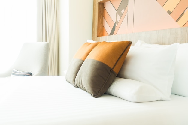 Łóżko z szarych i pomarańczowych poduszkach