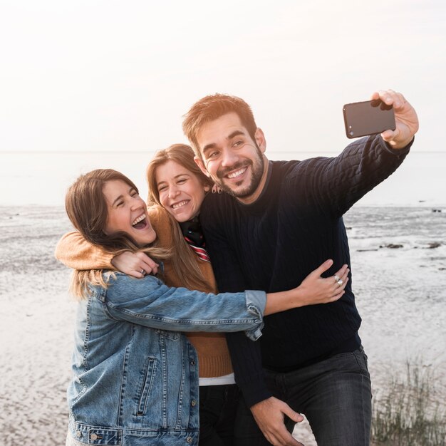 Ludzie biorący selfie na brzegu morza