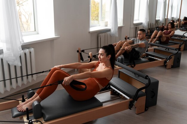 Ludzie biorący udział w zajęciach Pilates Reformer