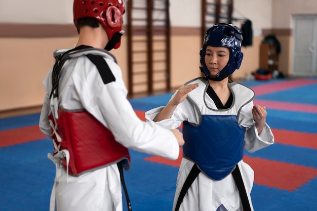 Ludzie ćwiczący taekwondo w sali gimnastycznej