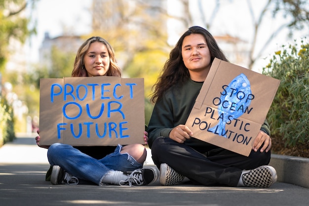 Ludzie podczas Światowego Dnia Ochrony Środowiska protestują na zewnątrz z plakatami