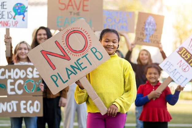 Bezpłatne zdjęcie ludzie protestujący z plakatami na zewnątrz z okazji światowego dnia ochrony środowiska