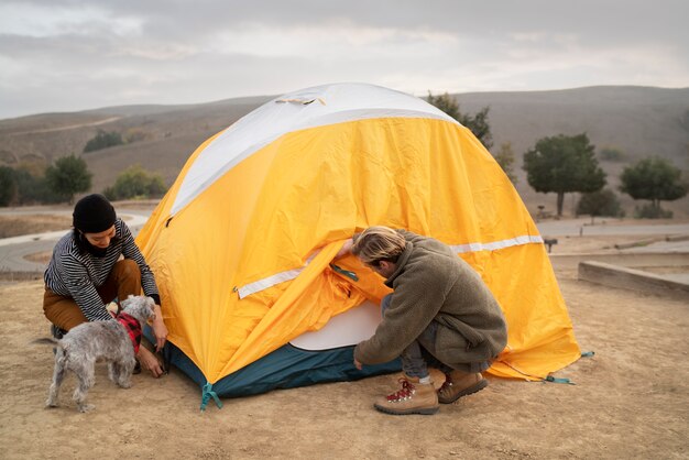 Ludzie przygotowujący namiot do zimowego biwakowania