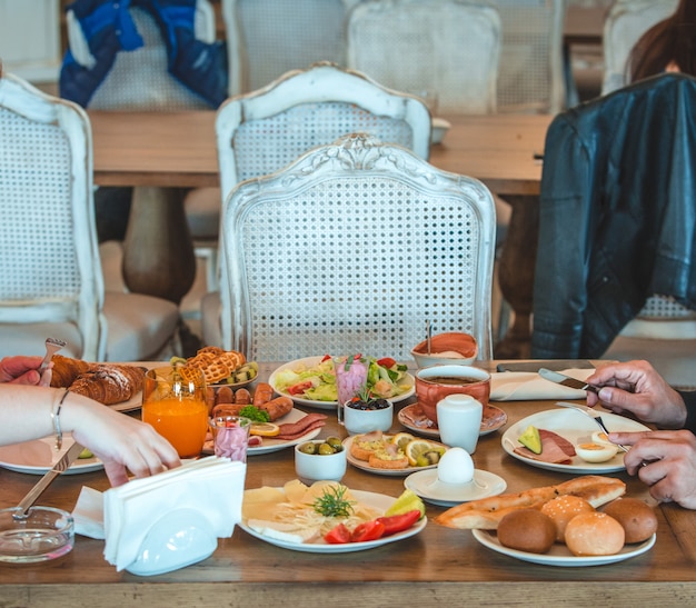 Bezpłatne zdjęcie ludzie siedzący przy stole śniadaniowym w restauracji