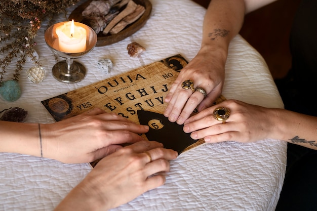 Ludzie używający starej drewnianej tablicy ouija