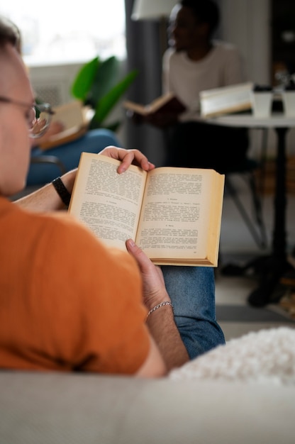 Ludzie w bibliotece lub klubie czytelniczym uczący się z książek