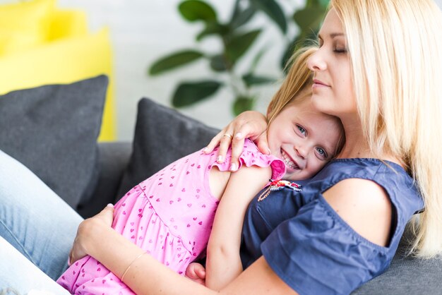 Bezpłatne zdjęcie macierzysty przytulenie jej uśmiechnięta mała córka