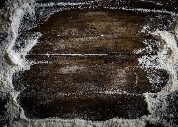 Mąka rozsypana na drewnianym stole