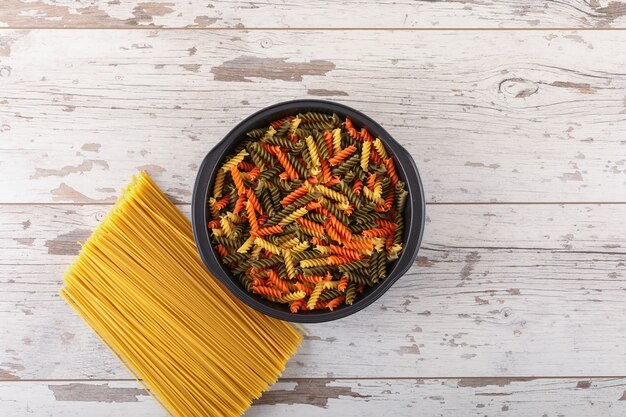 makaron spaghetti i gemelli na białej powierzchni drewnianych