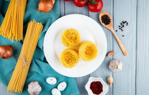 Makaron tagliolini na białym talerzu linguini spaghetti jaj czosnku cebula widok z góry