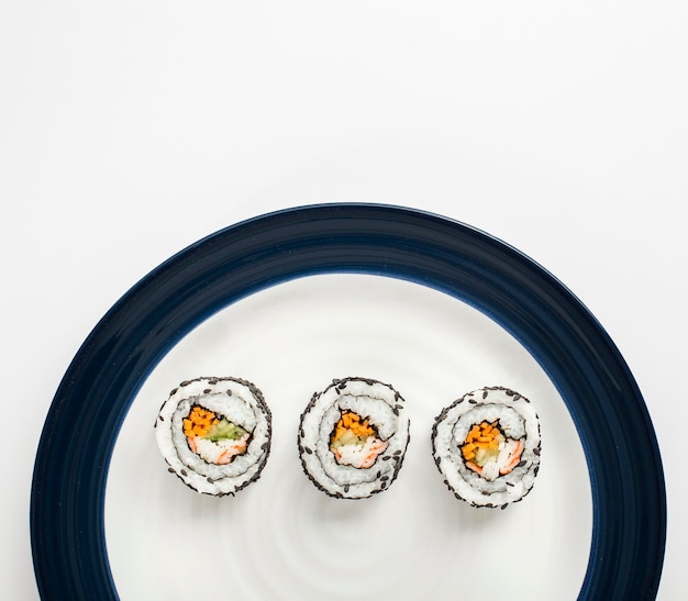 Maki sushi rolki na białym i błękitnym talerzu