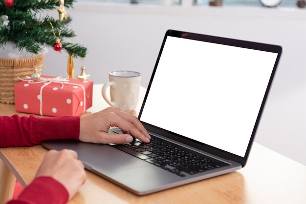 Makieta laptopa z białym ekranem na stole biurowym
