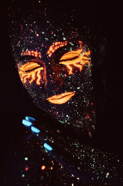 Makijaż ultrafioletowy. Portret dziewczynki namalowany proszkiem fluorescencyjnym. Koncepcja Halloween. Galaktyka śpi.