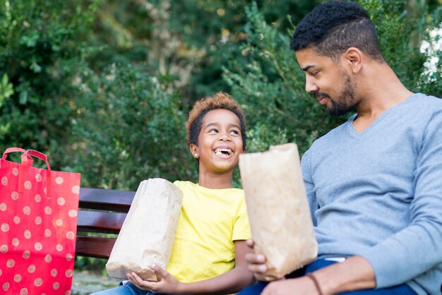 Mała Afroamerykańska Dziewczyna Jedzenie Popcornu Z Ojcem W Parku